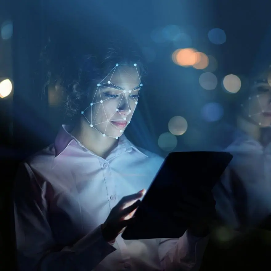 Woman using facial recognition technology to access her tablet computer